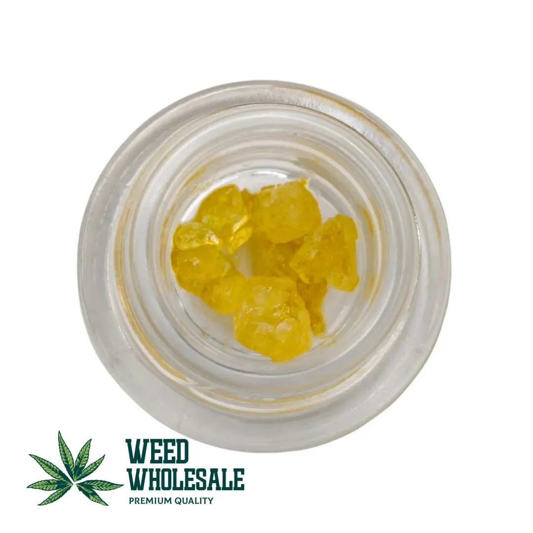 Golden yellow crystals of THC Diamonds – 1G cannabis concentrate in a transparent grass jar