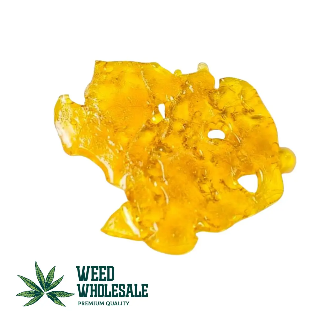 A translucent golden shinny slab of premium shatter concentrate.